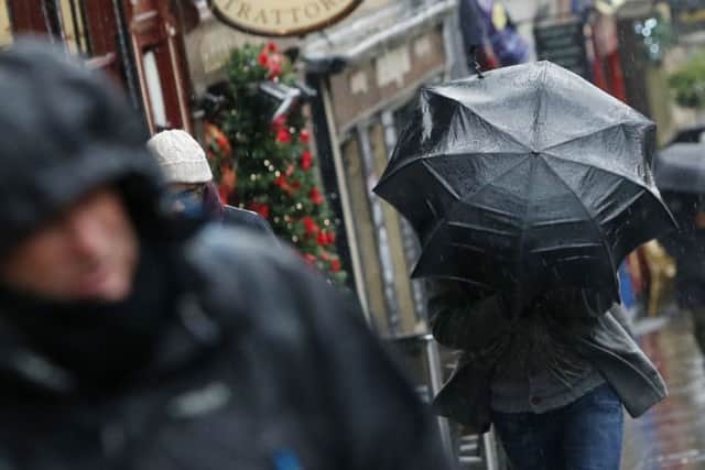 A person with an umbrella on the Royal Mile in Edinburgh as Britain is set to battered by a "weather bomb". PRESS ASSOCIATION Photo. Picture date: Tuesday December 9, 2014. Widespread weather warnings have been issued as a so-called "weather bomb" is set to batter parts of Britain. Winds of around 80 miles per hour are expected to hit the UK this evening, with severe gales expected across north Wales, Scotland, northern England and Northern Ireland for about 48 hours. See PA story WEATHER Cold. Photo credit should read: Danny Lawson/PA Wire