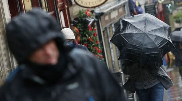 A person with an umbrella on the Royal Mile in Edinburgh as Britain is set to battered by a "weather bomb". PRESS ASSOCIATION Photo. Picture date: Tuesday December 9, 2014. Widespread weather warnings have been issued as a so-called "weather bomb" is set to batter parts of Britain. Winds of around 80 miles per hour are expected to hit the UK this evening, with severe gales expected across north Wales, Scotland, northern England and Northern Ireland for about 48 hours. See PA story WEATHER Cold. Photo credit should read: Danny Lawson/PA Wire