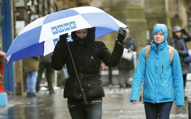 A woman with an umbrella on the Royal Mile in Edinburgh as Britain is set to battered by a "weather bomb". PRESS ASSOCIATION Photo. Picture date: Tuesday December 9, 2014. Widespread weather warnings have been issued as a so-called "weather bomb" is set to batter parts of Britain. Winds of around 80 miles per hour are expected to hit the UK this evening, with severe gales expected across north Wales, Scotland, northern England and Northern Ireland for about 48 hours. See PA story WEATHER Cold. Photo credit should read: Danny Lawson/PA Wire