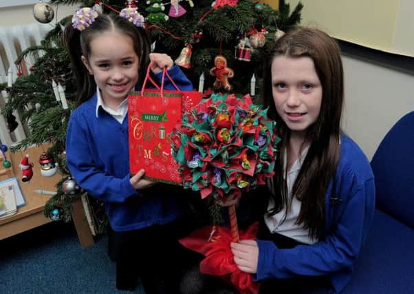 Nine year old Lia Watson who created a 'Sweet Tree', to raise funds, after her Grandfather was diagnosed with terminal Prostate Cancer. Lia held a raffle for the tree, at Langold Dyscarr Community school, which she attends. NWGU 15-12-14 Fundraiser,  Lia is pictured with the Tree, and her sister Kadi (5) who is holding a bag of Raffle tickets.  Kadi also attends the same school. ( 1 to 4)
