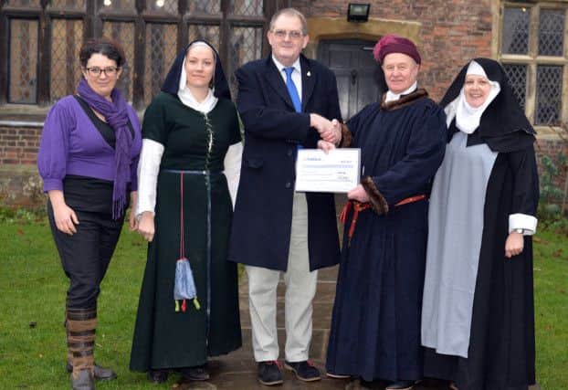 Coun Pat O'Connor hands over a cheque to Gordon Shaw of the Lord Burgh's Retinue and Laura Clark and Avril Sanderson of Gainsborough Old Hall Volunteer Sewing Group