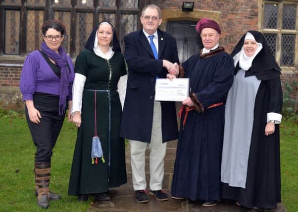 Coun Pat O'Connor hands over a cheque to Gordon Shaw of the Lord Burgh's Retinue and Laura Clark and Avril Sanderson of Gainsborough Old Hall Volunteer Sewing Group