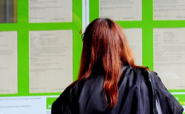 A woman looking into the window of a job centre.