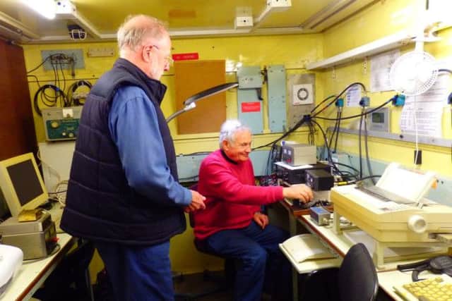 Radio club chairman Brian Spittlehouse and secretary Johhn Fennell make some fine adjustments to one of their radio sets.