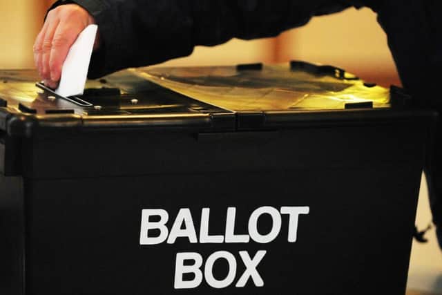File photo dated 06/05/2010 of a voter placing a ballot paper in the ballot box at the polling station at Market Hall in Swadlincote, Derbyshire. PRESS ASSOCIATION Photo. Issue date: Wednesday January 25, 2012. The law should be changed before the next general election to ensure voters queuing at the ballot box cannot be turned away at the close of polls, a cross-party committee of peers urged today. The House of Lords Constitution Committee called for legislation guaranteeing that voters who are at a polling station before 10pm are entitled to cast their ballot. See PA story POLITICS Voting. Photo credit should read: Rui Vieira/PA Wire