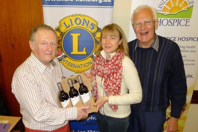 Isle of Axholme Lions held a quiz in Haxey Memorial Hall in aid of Lindsey Lodge Hospice. Pictured is question master Terry Condliff presenting the winning team captain Lorraine Pepper with the team's prize, watched by event organiser Peter Lindley.