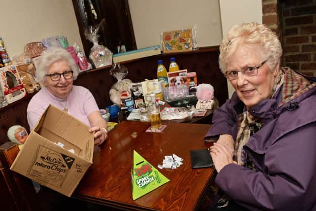 Betty Phillips, volunteer, pictured serving Barbara Kirkham, of Crowle, on the tombola stall.