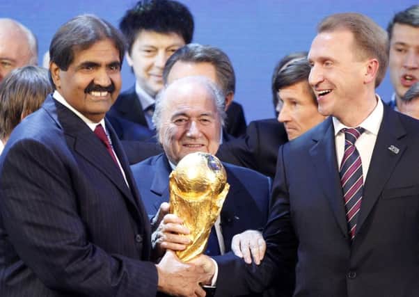 FIFA President Sep Blatter is flanked by Russian Deputy Prime Minister Igor Shuvalov, right, and Sheikh Hamad bin Khalifa Al-Thani, Emir of Qatar, after the announcement that Russia will host the  World Cup 2018 and Qatar 2022.