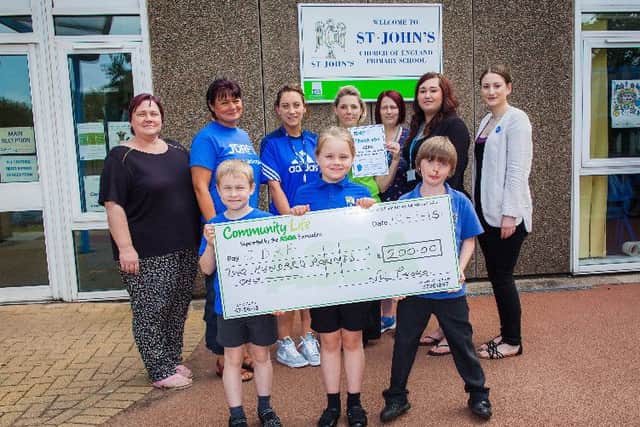 Nicola Peake, of Community Life at Asda Celtic Point, presents a cheque for £200 to St John's Primary Schoolin Worksop to add to their fundraising account for Type 1 Diabetes charity JDRF. Also pictured are Sadie Munro (right) from JDRF North) school staff and Year Three pupils Andrew Ferrol, Chloe Hind and Dylan Peake. Picture: Rob Ferrol