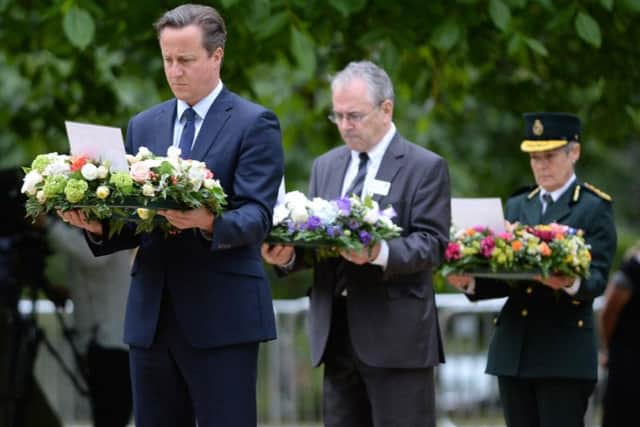 Prime Minister David Cameron, Transport Commissioner Sir Peter Hendy and Dr Fiona Moore, Chief Executive of London Ambulance, carry wreathes at the July 7 memorial in Hyde Park, London, as Britain remembers the July 7 attacks amid a welter of warnings about the enduring and changing threat from terrorism a decade on.