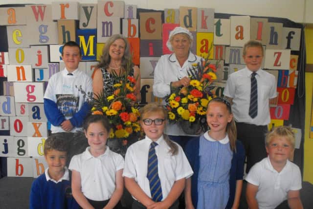 Val Cumbor, school cook is retiring after 19 years on the right and Sue Kirk, Teaching Assistant retiring after 20 years, on the left with several children at Auckley School.