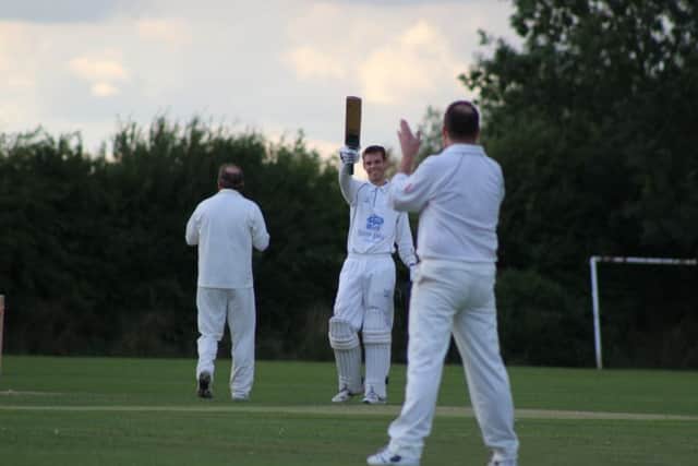 Tom Lane raises his bat having made a century for Roses