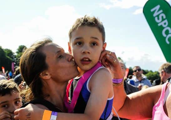 Bailey Matthews 8 from Doncaster gets a kiss from his mother Julia after he crossed the finish line to complete his first ever triathlon at Castle Howard on sat.