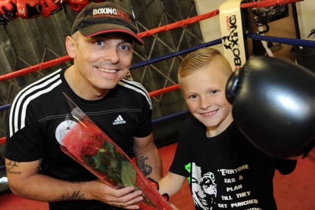 Eight year old Kian Bak, presents, Chris Boyle, the owner of X Boxing Academy with his Guardian Rose.