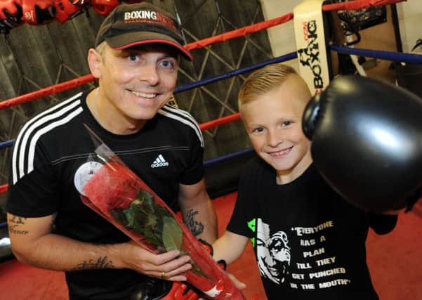Eight year old Kian Bak, presents, Chris Boyle, the owner of X Boxing Academy with his Guardian Rose.