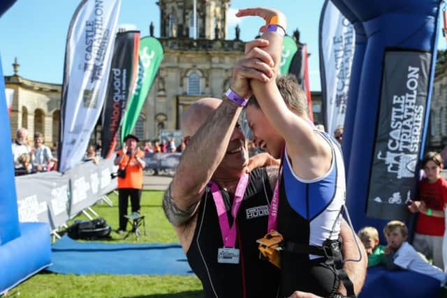 Bailey Matthews 8 from Doncaster is congratulated by his Dad Jonathan after crossing the finish line to complete his first ever triathlon at Castle Howard on sat.