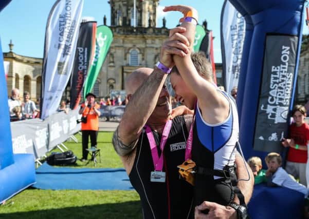 Bailey Matthews  8 from Doncaster is congratulated by his Dad Jonathan  after  crossing  the finish line  to complete his first ever triathlon at Castle Howard on sat.