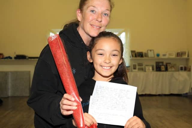 Evie Dennington, eight, presents the Guardian Rose Award to her dance teacher Donna Pressley from the Donna Pressley Dance Academy in Worksop.