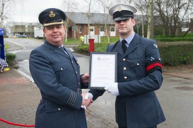 Group Captain Bailey (L) presents Corporal Longstaff the Physical Education Certificate
