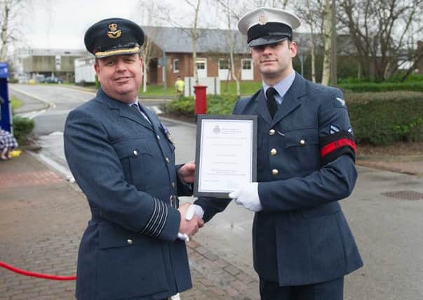 Group Captain Bailey (L) presents Corporal Longstaff the Physical Education Certificate