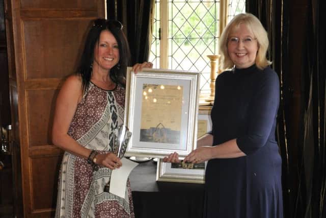 Mandy Coggan (left, receiving her prize from Angela Meads) has won the North Nottinghamshire Short Story Competition
