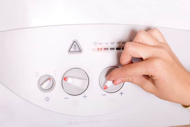 A person fiddling with their boiler. Picture credit: PA Photo/thinkstockphotos.