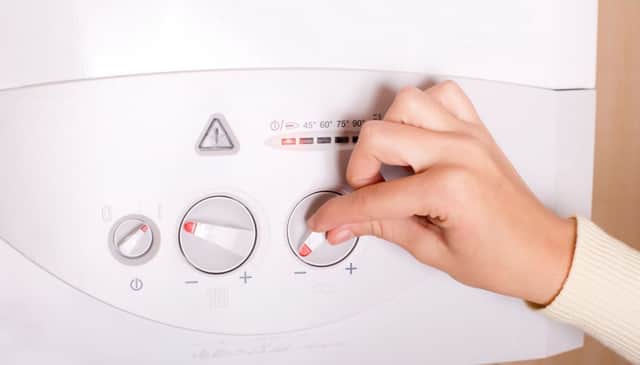 A person fiddling with their boiler. Picture credit: PA Photo/thinkstockphotos.