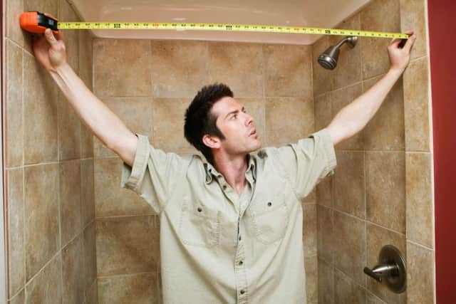 A man measuring up for tiles in the bathroom. Picture: PA Photo/thinkstockphotos.