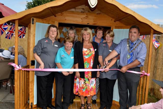 Garden party to celebrate the opening of Foxby Court Care Homeâ¬"s new garden and summer house. Gainsborough Mayor Coun Ken Woolley cuts the ribbon with home manager Tracy Turfrey and staff