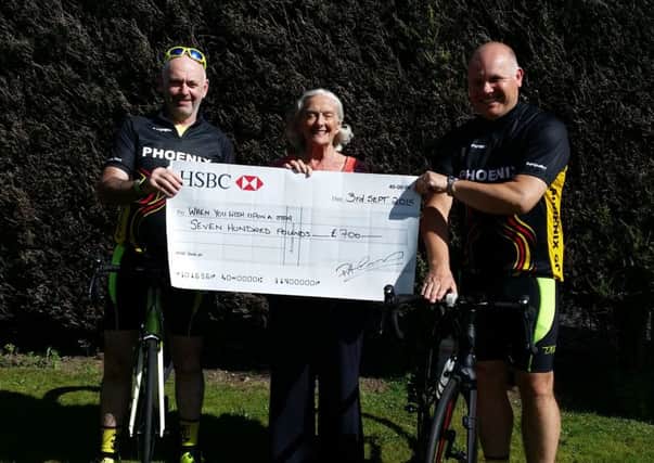 CHARITY CHEQUE -- Phoenix cyclist Pete Comerford, with help from support-vehicle driver Jon Findley, presents a cheque for Â£700 to Pat Wright, from the When You Wish Upon A star charity, after completing the 170-mile Way Of The Roses coast-to-coast ride from Morecambe to Bridlington, solo, in 21 hours, 25 minutes.