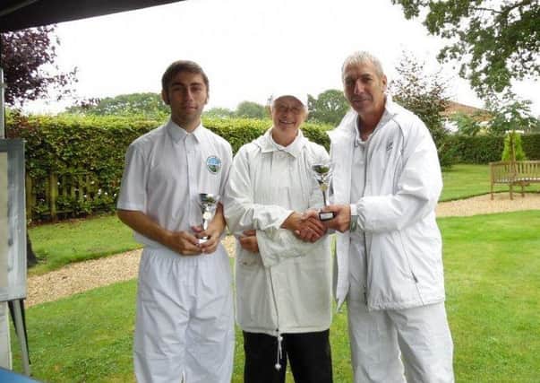 WET WINNERS! -- father and son Mike and Richard Bilton receive the Jubilee Park Invitation Cup from Cass Hewson, of Woodhall Spa Croquet Club.