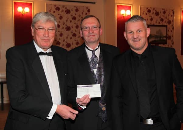 SPORTING GESTURE -- a typical cheque presentation by Gainsborough Sporting Club as chairman Dave Belton (centre) hands over Â£500 to Geoff Holmes (left), director of Gainsborough Trinity Football Club, watched by Hull City legend Dean Windass.