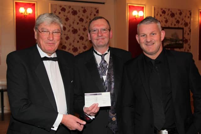 SPORTING GESTURE -- a typical cheque presentation by Gainsborough Sporting Club as chairman Dave Belton (centre) hands over £500 to Geoff Holmes (left), director of Gainsborough Trinity Football Club, watched by Hull City legend Dean Windass.