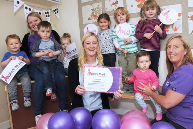 Nursery manager, Jacqui Hannaby, centre, with her deputies, Avril Lee, right and Amy Graney and some of the children who attend the ursery after receiving the Millie's Mark award.