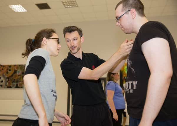 Students Caitlin Maxwell-Sinclair and Aaron Raw (right) get a combat lesson from Rob Leonard
