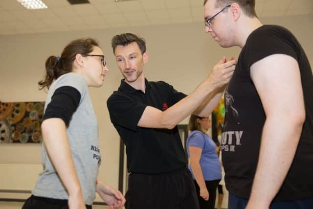 Students Caitlin Maxwell-Sinclair and Aaron Raw (right) get a combat lesson from Rob Leonard
