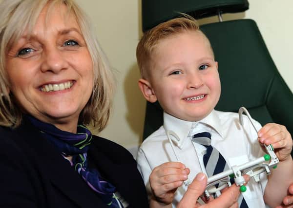 Four year old Daniel Lee takes a trip back to Worksop's Specsavers shop on Bridge Street, to thank them for the attention shown by optician Mohamed Suhail who picked up a medical emergency, showing him round is manager Tracey Jeffery.