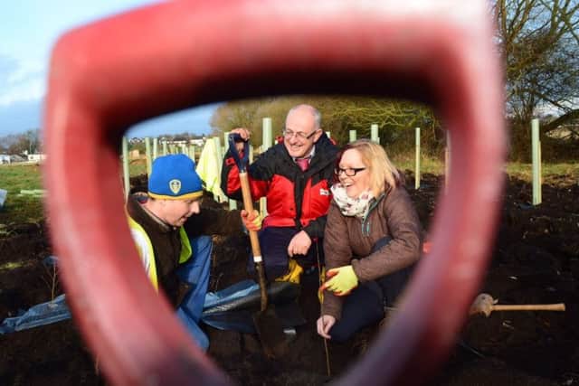 Mark Hutchinson of Western Power Distribution (centre) plants a tree with volunteers Jonathan Roy and Tracy Brundell