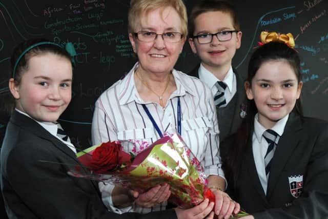 Year six pupils from the Sparken Hill Academy from left, Lucy Hobson, Max Phillipson and Trinity Searles present their retiring lunch-time manager Jenny Lee with the Guardian rose on the last day of term.