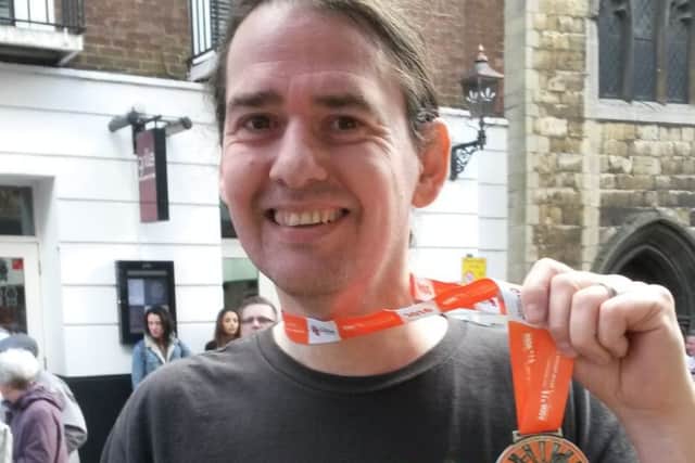 Charity champion Neal Handley-Sawer with his medal for finishing last year's Lincoln 10K.