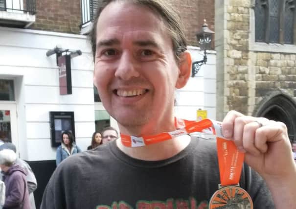 Charity champion Neal Handley-Sawer with his medal for finishing last year's Lincoln 10K.