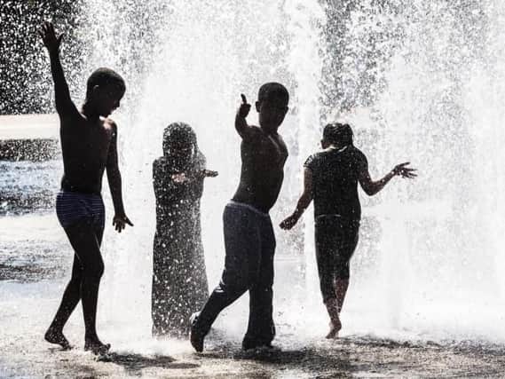 Children play in a water fountain as Britain basks in glorious sunshine and high temperatures.