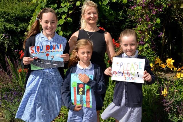 Children at St PeterÃ¢Â¬"s C of E Primary School took part in a road safety sign competition, pictured are Amy Clapperton, 11, Katy Cowland, seven and Rose Mee, eight with Coun Karen Newsome