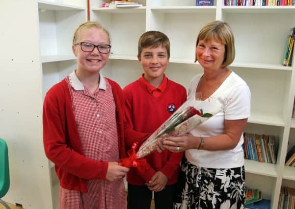 Holly primary pupils Liberty Wright and Lawrence Ellis present the rose to Anne Woodhead.