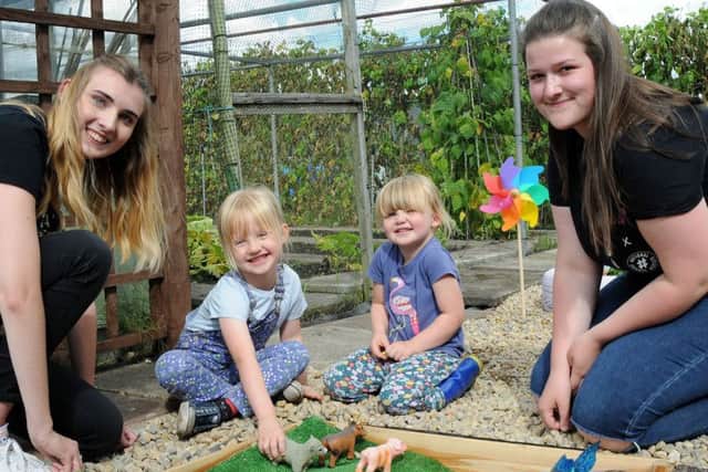 NCS students, Jessica Smith, left and Jess Gibbard keep Martha Hill, 5, and her 3 year old sister Edith, amused in the sand pit during their visit to the revamped allotment site.