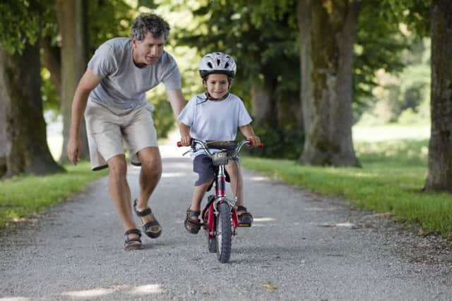 Father teaching his son to ride a bike