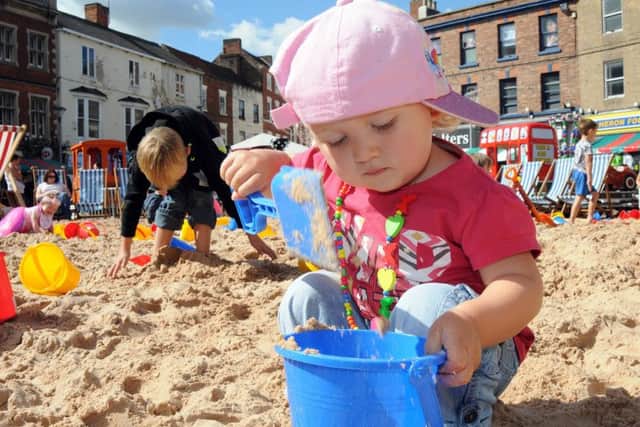 One-year-old Elsie Kleinhofs practices sand castle building. Photos by Anne Shelley.