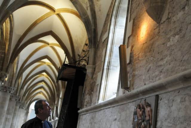Fr. Nicholas Spicer in the Priory Church where the carved face has been discovered.