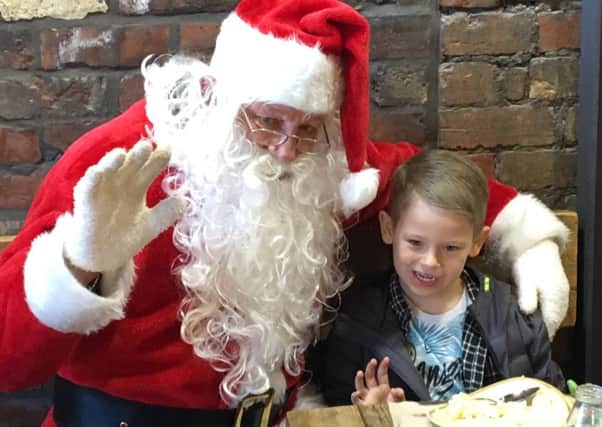 Father Christmas at Root and with five year old Riley Vernon - one of the competition winners.