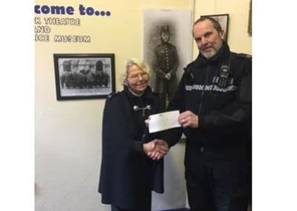 PC Ian Shaw presents a cheque for Â£450 to Eleanor Bowker.